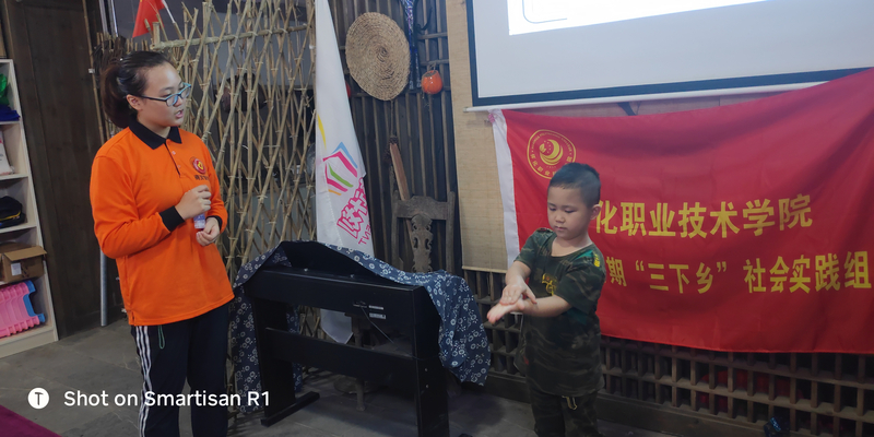 图为志愿者在教留守小朋友学习“七步洗手法”.jpg